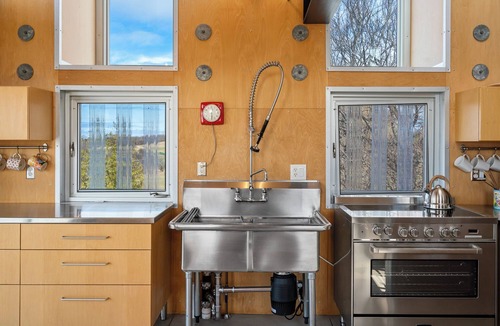 Northport House | Award-winning 9-level Chameleon House in Leelanau County. A modern-industrial masterpiece with reflective siding, rooftop deck, and epic Lake Michigan views near beaches and Fishtown.