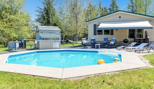 Brand new listing! Relax and unwind at this stunning Northwoods pool house featuring a private in-ground pool, fire pit, patio, garage space, and sleeping for 11 guests!